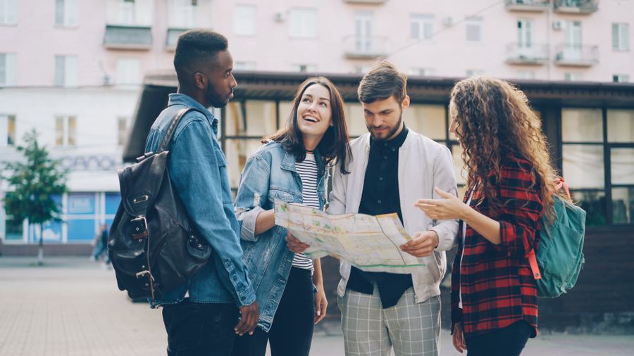 A diverse group of friends checking a map together while traveling