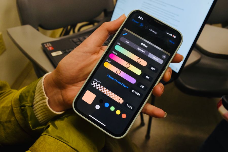 Hand holding a smartphone while checking its settings